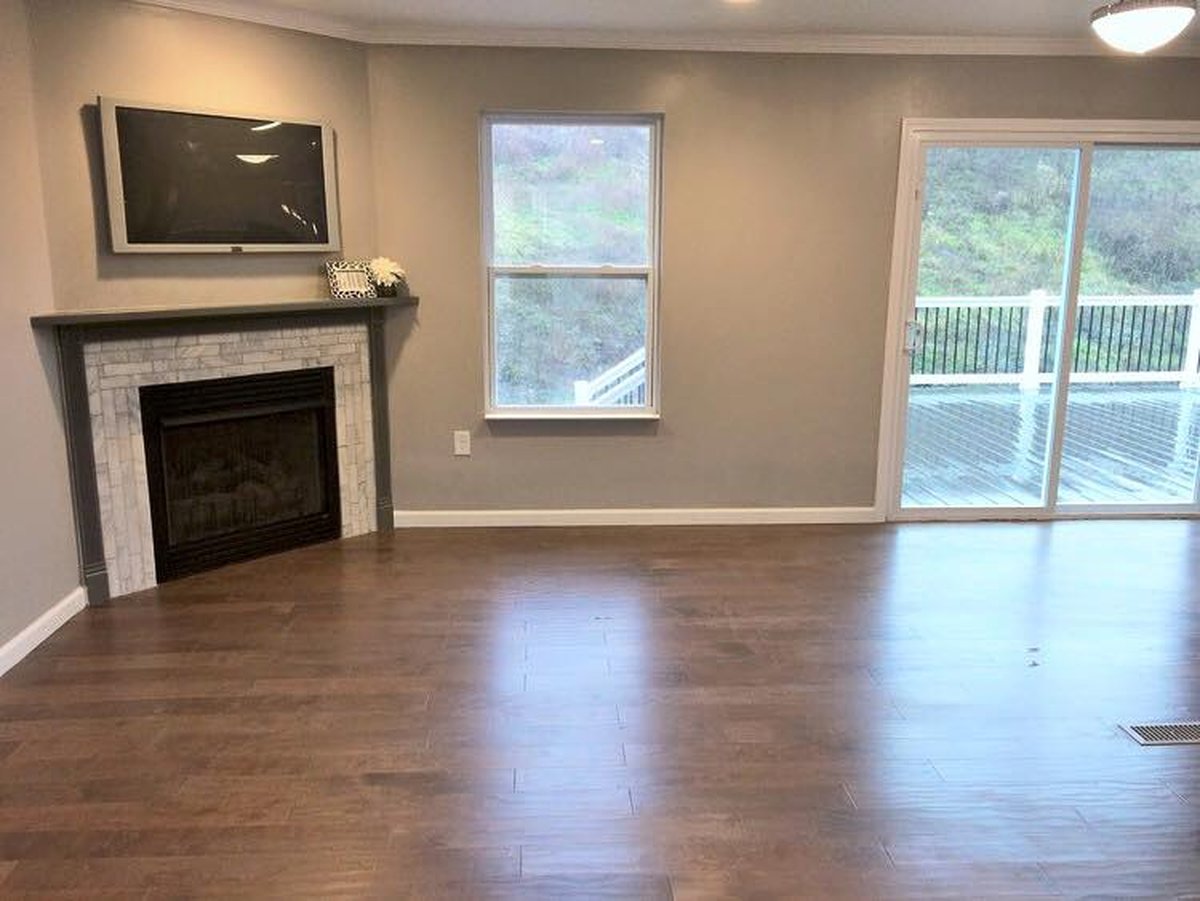 A finished living room with a fireplace and a sliding door out to a deck.